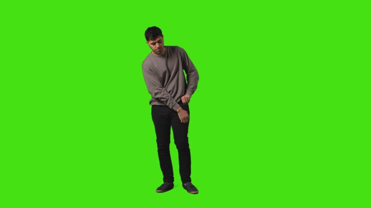 Young Man Getting Alert And Looking At Text Message On Mobile Phone Standing Against Green Screen 4