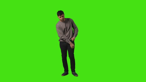 Young-Man-Getting-Alert-And-Looking-At-Text-Message-On-Mobile-Phone-Standing-Against-Green-Screen-4