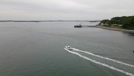 Aerial-fly-over-of-small-fishing-boat-travelling-away-from-island,-drone-flying-straight