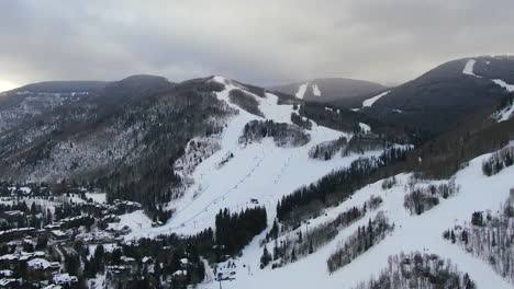 Aerial-Cinematic-Drone-Vail-Village-Vail-ski-resort-Lions-Head-early-morning-mid-winter-sunrise-of-ski-trails-and-gondola-scenic-mountain-landscape-of-Colorado-downward-movement