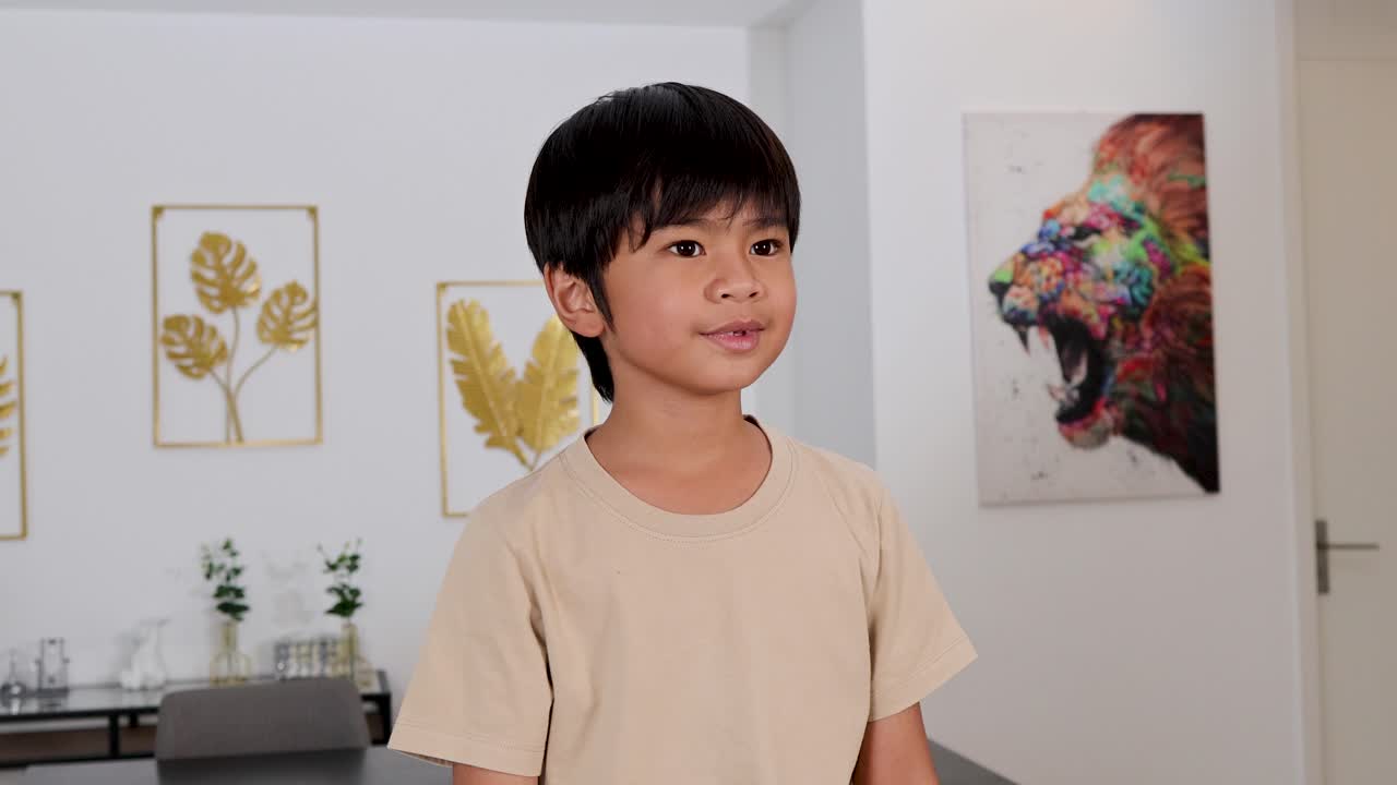 Young boy smiles, points, and gestures playfully in a bright, contemporary living room setting