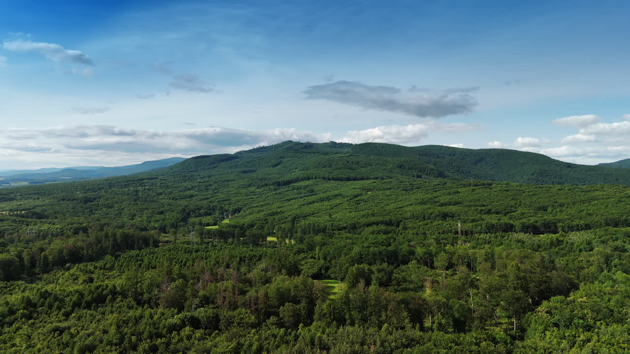 Rising above the lush green forests covering the scenery. Verdant mountains at backdrop.