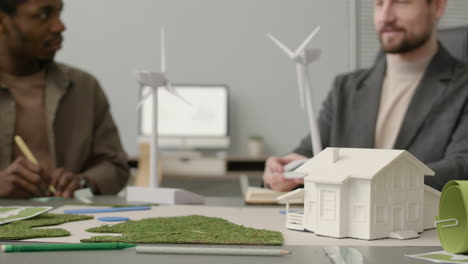 businessman explaining wind turbine model to colleagues in the office 1