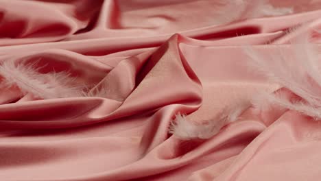 pink satin fabric with feathers
