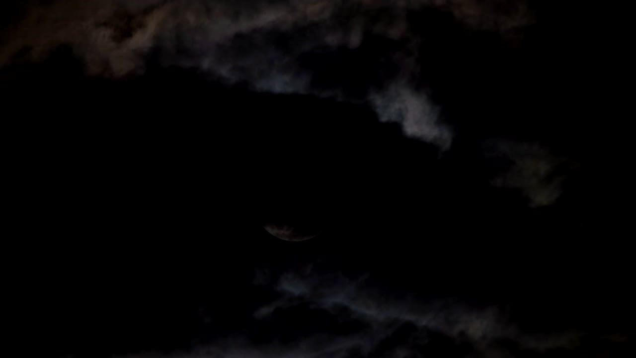 полнолуние за драматическими облаками на ночном небе