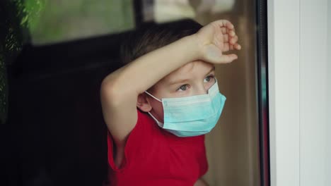 young boy in a medical mask looks out the window 03