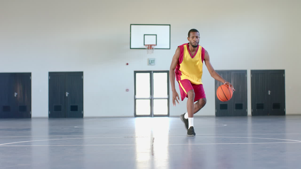 hombre afroamericano jugando al baloncesto en el interior