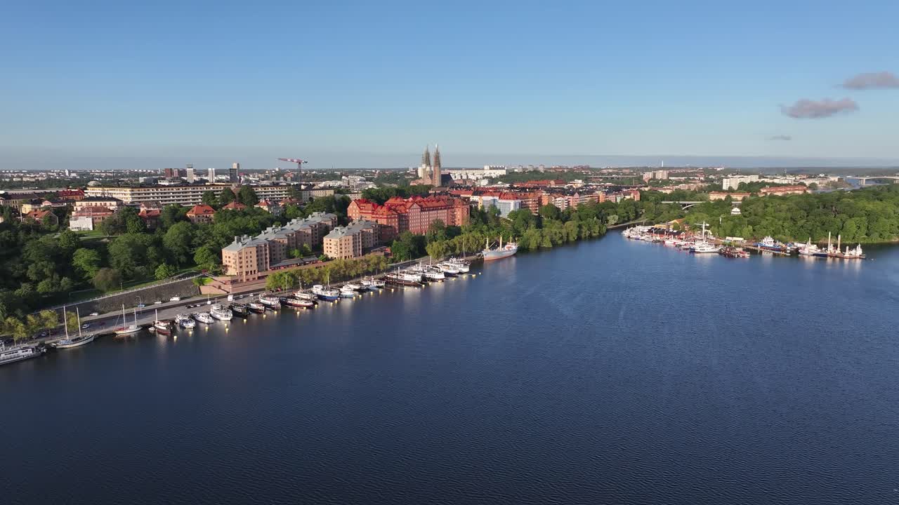 Panorama urbano di Stoccolma sul lungofiume con edifici residenziali e barche.