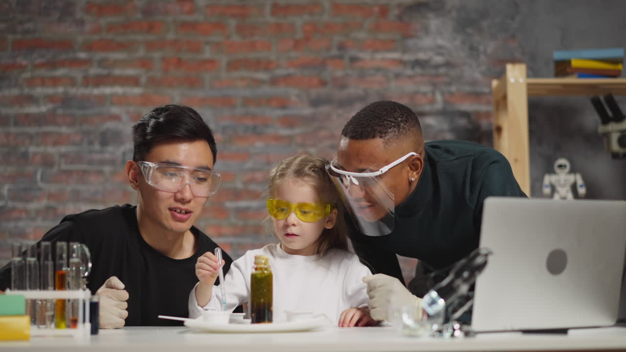 la niña gotea líquido azul con pipeta en el apoyo de los tutores en el laboratorio