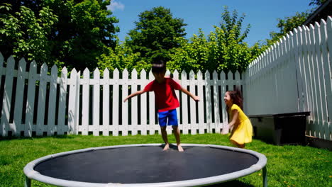 kids having fun jumping on a trampoline in the backyard