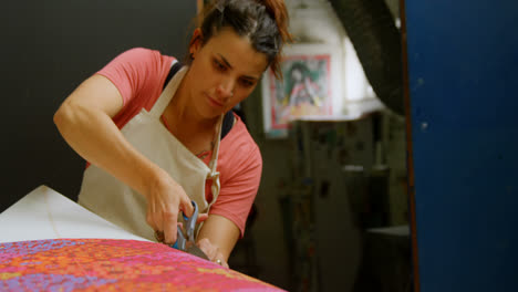 Woman-cutting-fabric-for-surfboard-4k