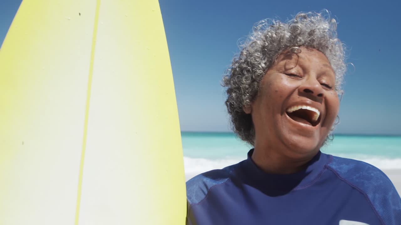 서프보드 를 들고 웃고 있는 고령 여성