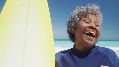 mujer mayor con una tabla de surf sonriendo