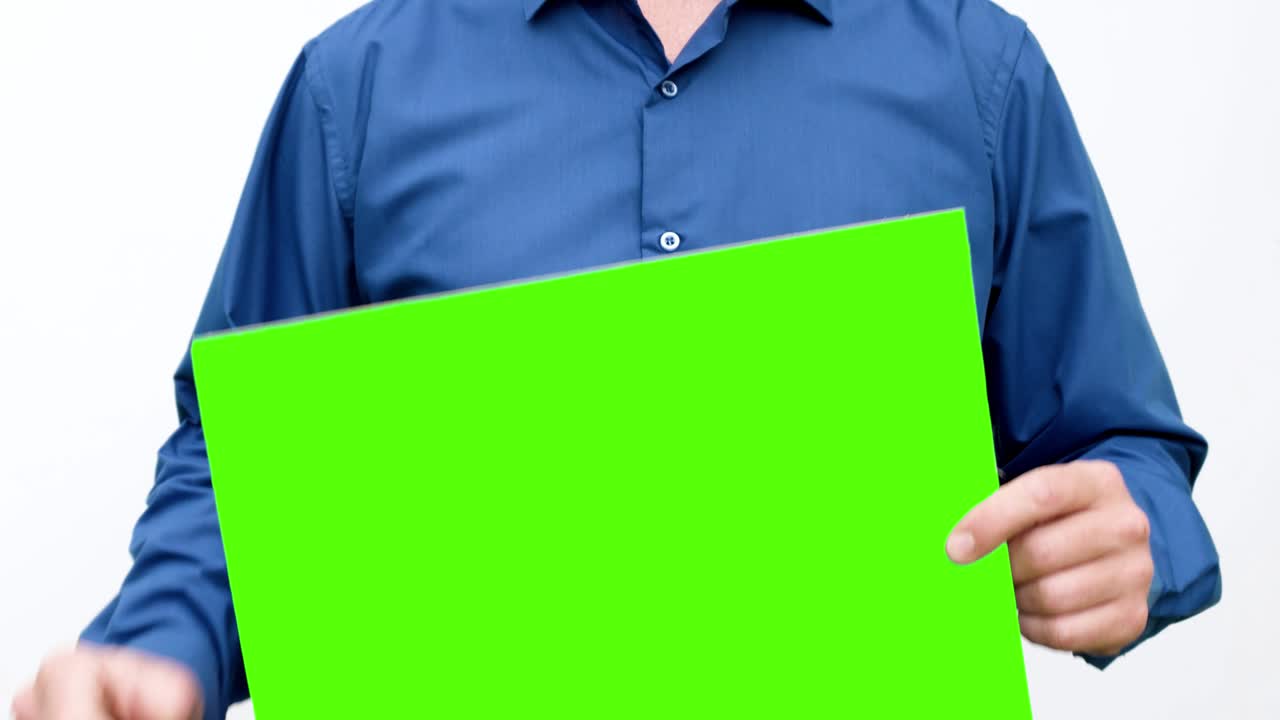 The person moves the green screen to the right and to the left. Looped video