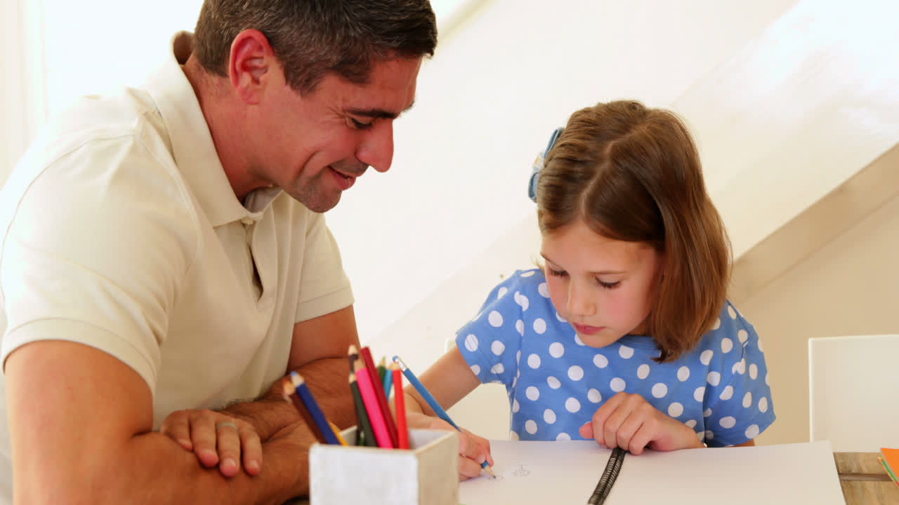 padre e hija dibujando juntos en la mesa