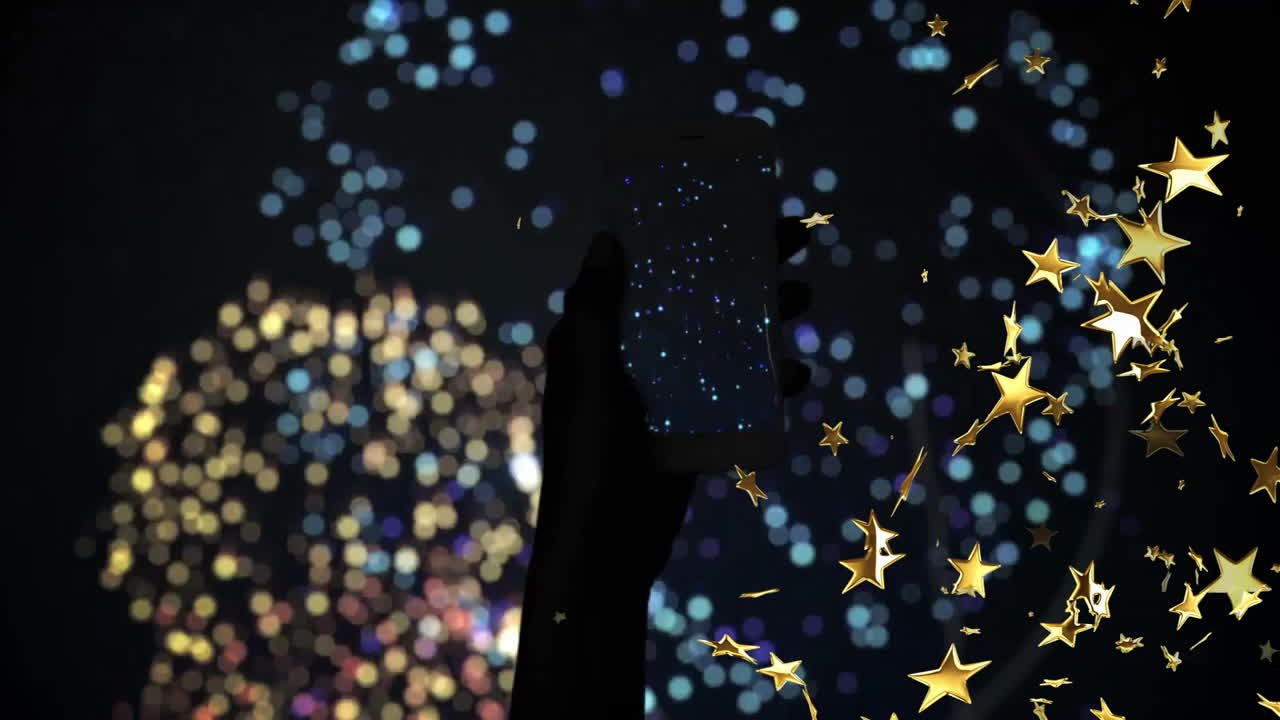 Holding smartphone with fireworks, golden stars animation over dark background