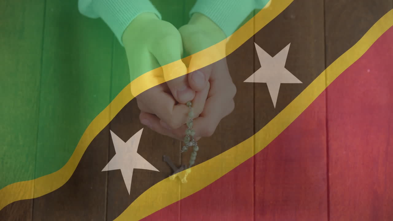 Holding rosary, hands over Saint Kitts and Nevis flag in animation style