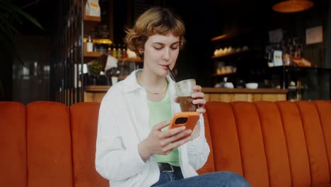 mujer usando un teléfono inteligente en un café