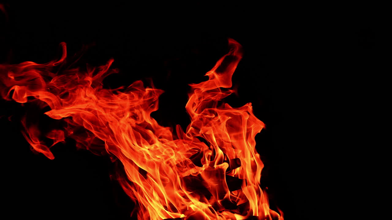 A stack of wood burns in the large bonfire. Beautiful view of campfire burning at night.