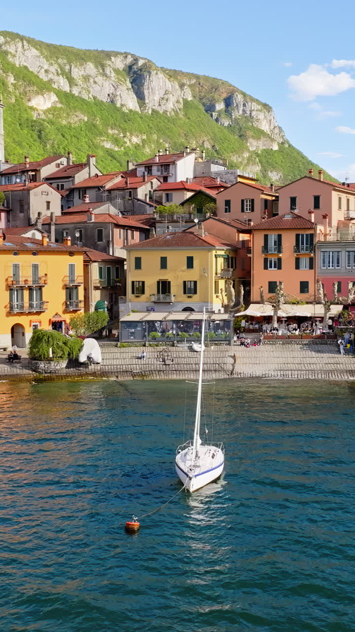 Aerial drone view of boats on the shore of Varenna, Italy near Lake Como. Vertical