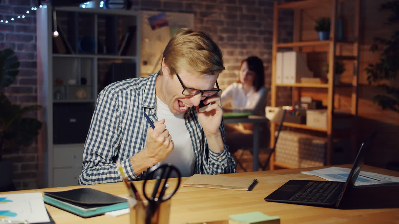 Business Person Talking on the Phone in Office at Night