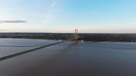 A cinematic vista: Humber Bridge shines in the sunset&#039;s warmth, with a procession of cars forming a mesmerizing spectacle