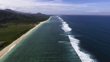 aerial view of tropical sand beach paradise with big white foam waves crashing on the barrier reef epic island seascape, west sumbava indonesia travel destination