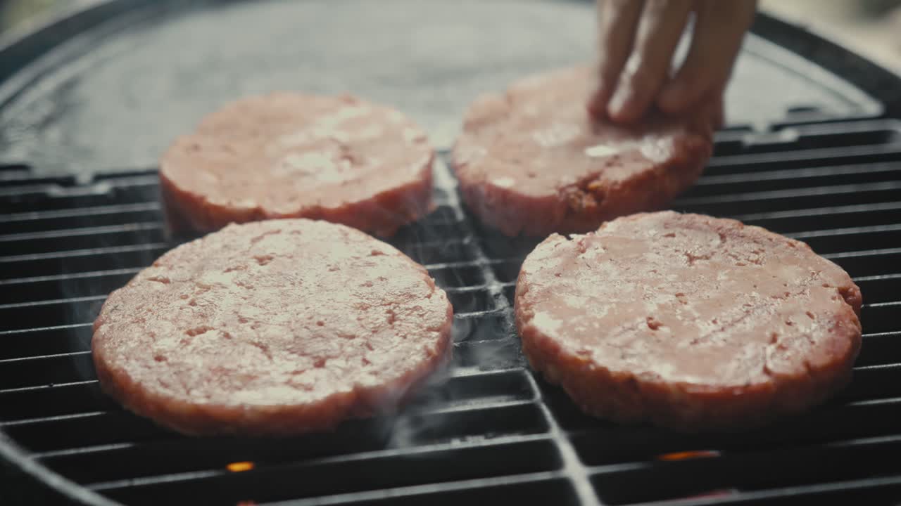 Raw hamburgers cooking on a grill