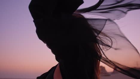 orbit medium shot around an arabian girl while she is holding up a waving black scarf in the fossils dunes dubai abu dhabi sharjah