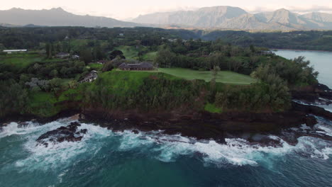 aerial of kauai hawaii coastline in the morning as waves crash against the rocks