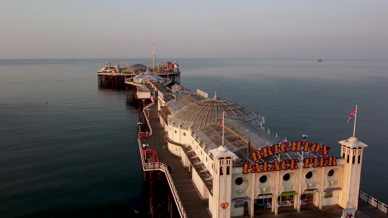 Altın saatte, martılar ve diğer kuşlar drone'a yakın uçarak toplanırken, Brighton İskelesi'nin denize doğru drone çekimi