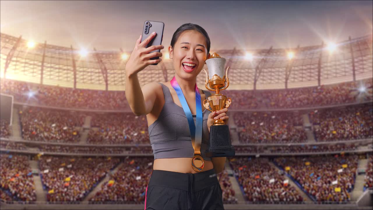 Asian Woman With A Gold Medal Holding A Gold Trophy And Taking Photo On Smartphone As The First Winner At The Stadium