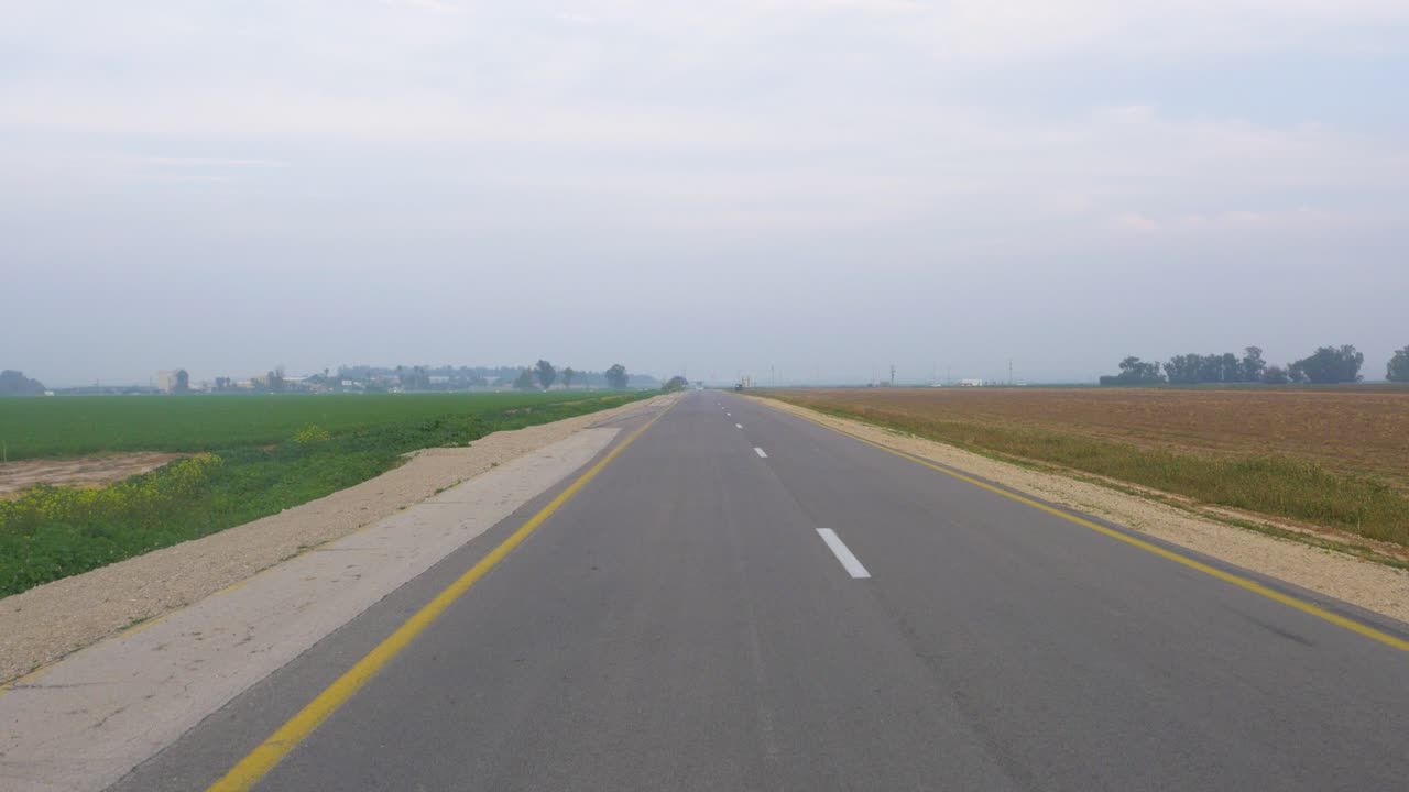 Aerial pedestal up as SUV car drives from under camera along country road