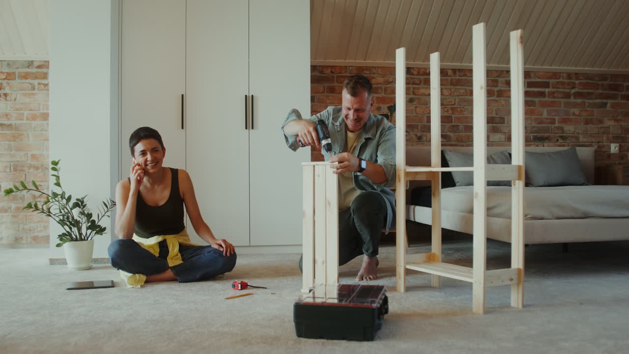 pareja montando estanterías de madera en casa