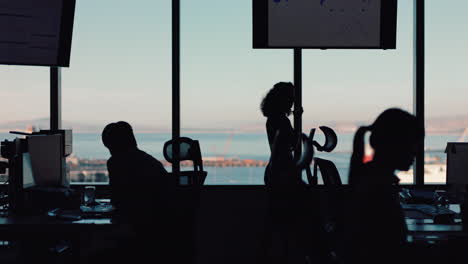 silhouette of business woman using smartphone having phone call chatting on mobile phone looking out window corporate executive discussing sales working late in busy office