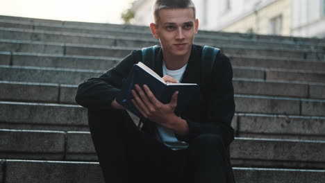 young student writing notes outdoors.