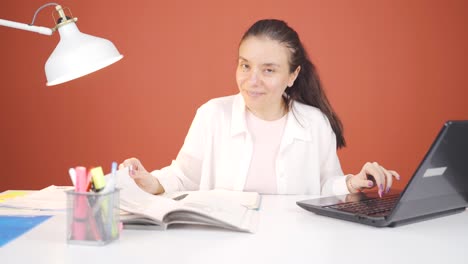 mujer trabajando en una computadora portátil con expresión feliz.