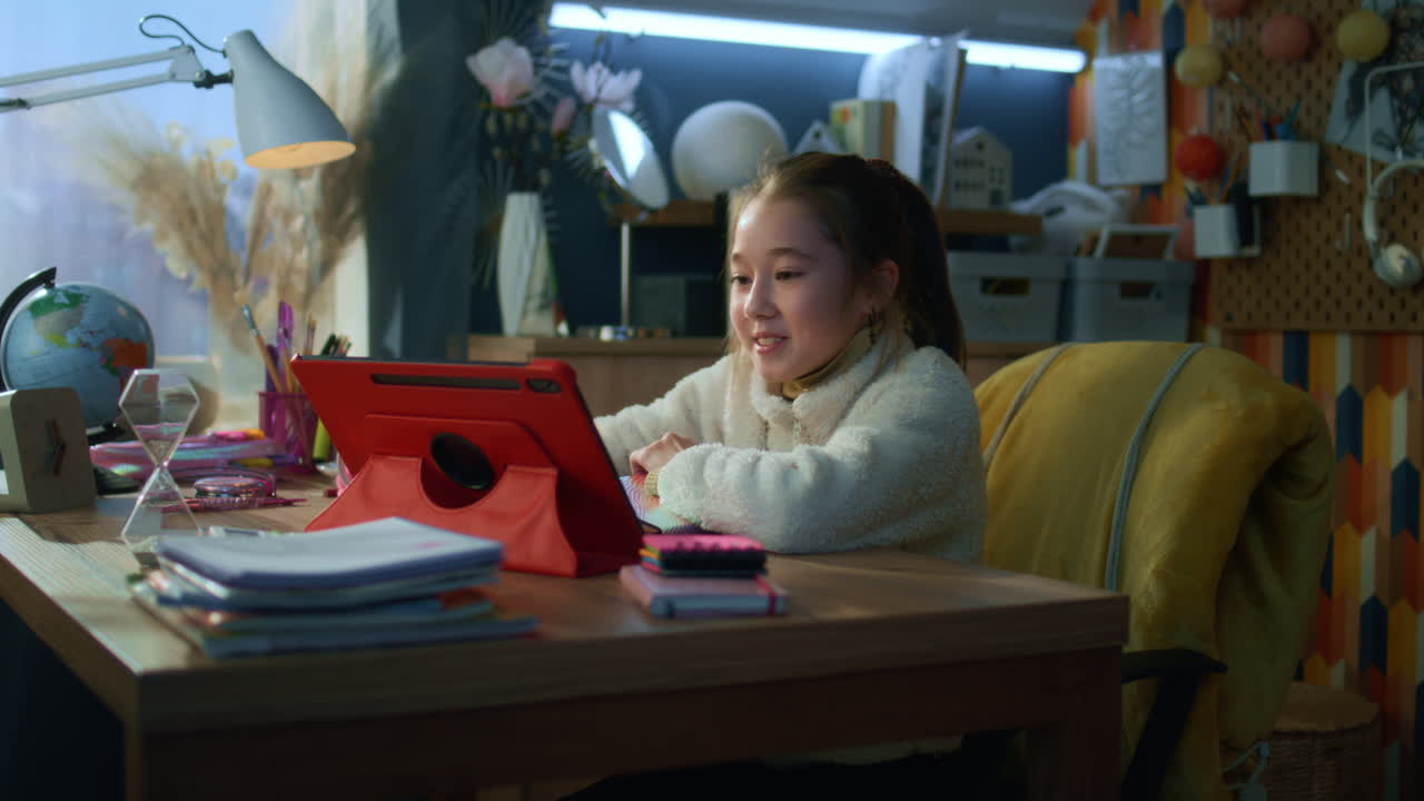 Girl studying at desk with tablet