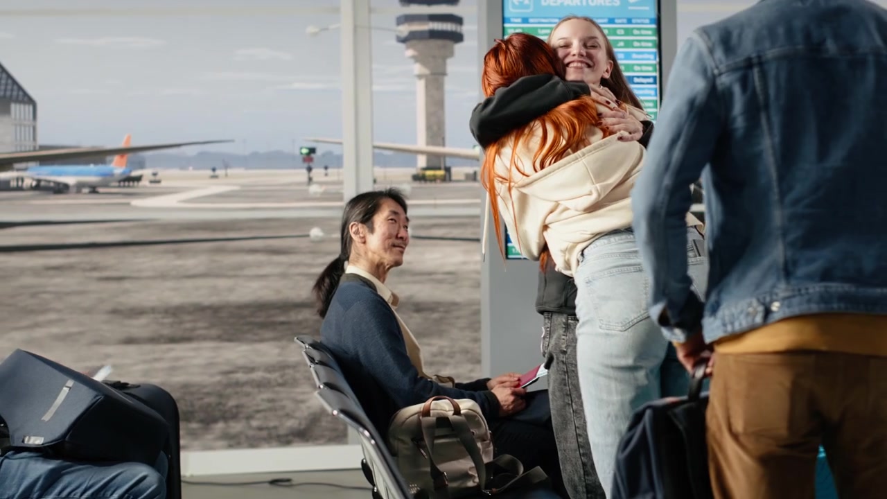Persone multietniche che parlano e aspettano di prendere l'aereo in un aeroporto affollato.