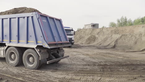 dump trucks loading sand at construction site
