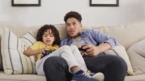 Happy-biracial-man-and-his-son-playing-video-games