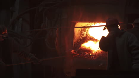 steel mill workers inspecting molten metal