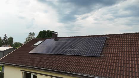 rooftop with solar panels installed on the house during daytime, orbital shot