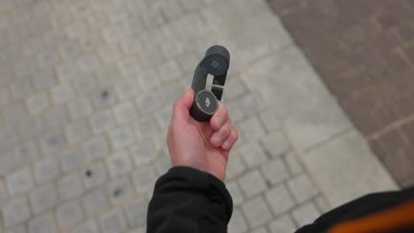 person manipulating a professional compact video stabilizer and connecting a mobile phone