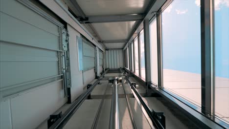 cabina de ascensor se mueve hacia arriba dentro del eje del ascensor iluminado con hidráulica con muchos pisos a cámara lenta