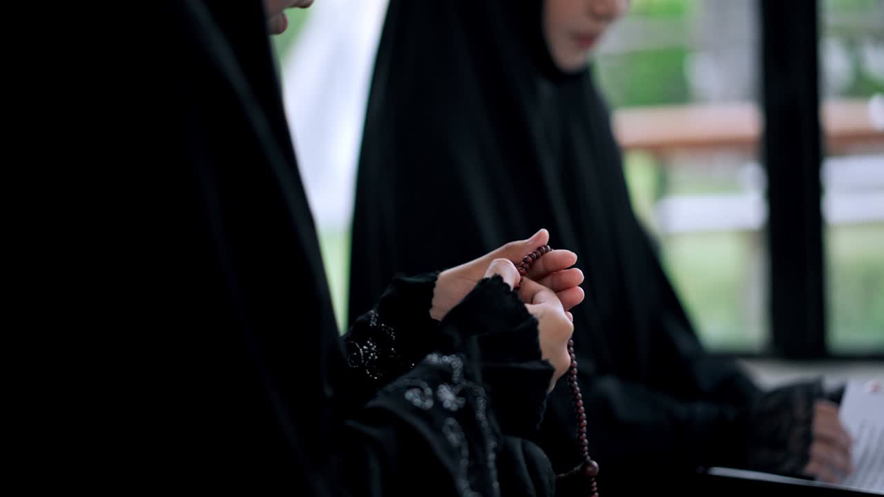 쿠란을 읽는 동안 젊은 무슬림 여성의 손을 가까이 들고