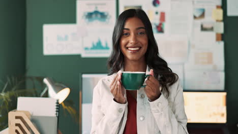 portrait of a smiling woman in an office holding a cup