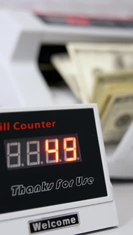 electronic device showing the amount of money. equipment for counting money. money are counted in a calculating machine. automatic equipment for banking financial transactions. vertical video
