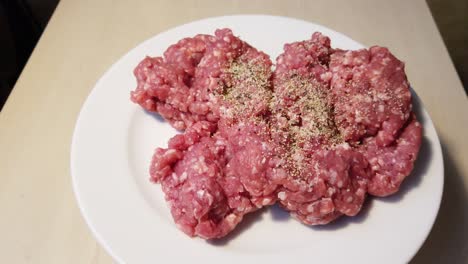 espolvorear carne molida en un plato con especias