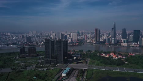 Aerial-panorama-Vietnam,-Ho-Chi-Minh-City-Skyline-panorama-on-sunny-clear-day-featuring-key-buildings,-architecture,-Saigon-River-and-Cruise-Ship